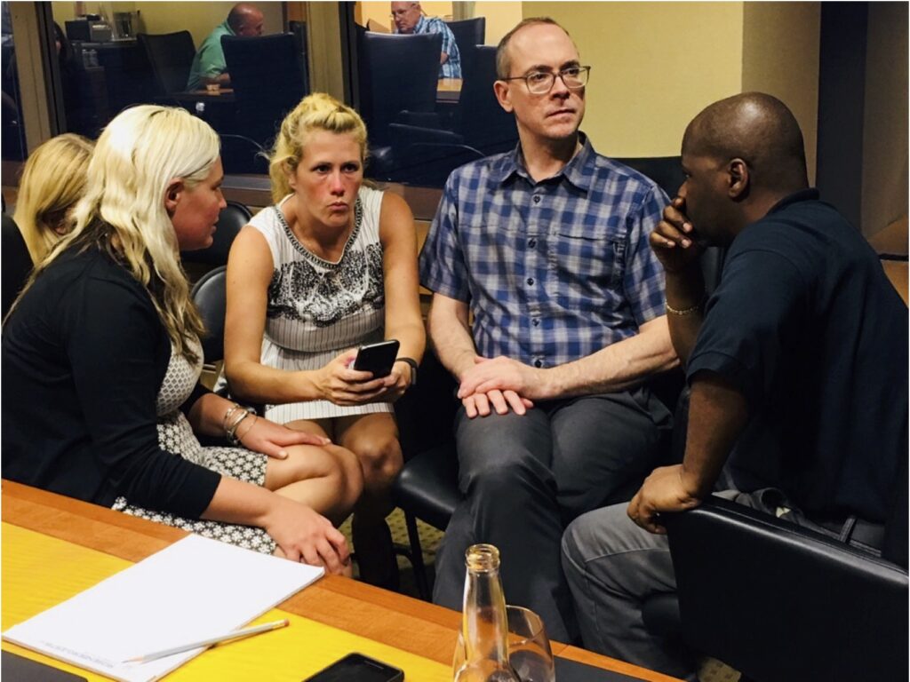 A diverse team of players in deep concentration during a Big Quiz Thing event.