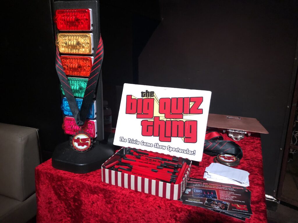 Awards and a buzzer tower displayed at a Big Quiz Thing event.