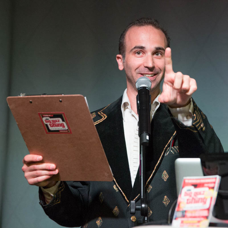 Noah Tarnow hosting a Big Quiz Thing event, holding a clipboard.